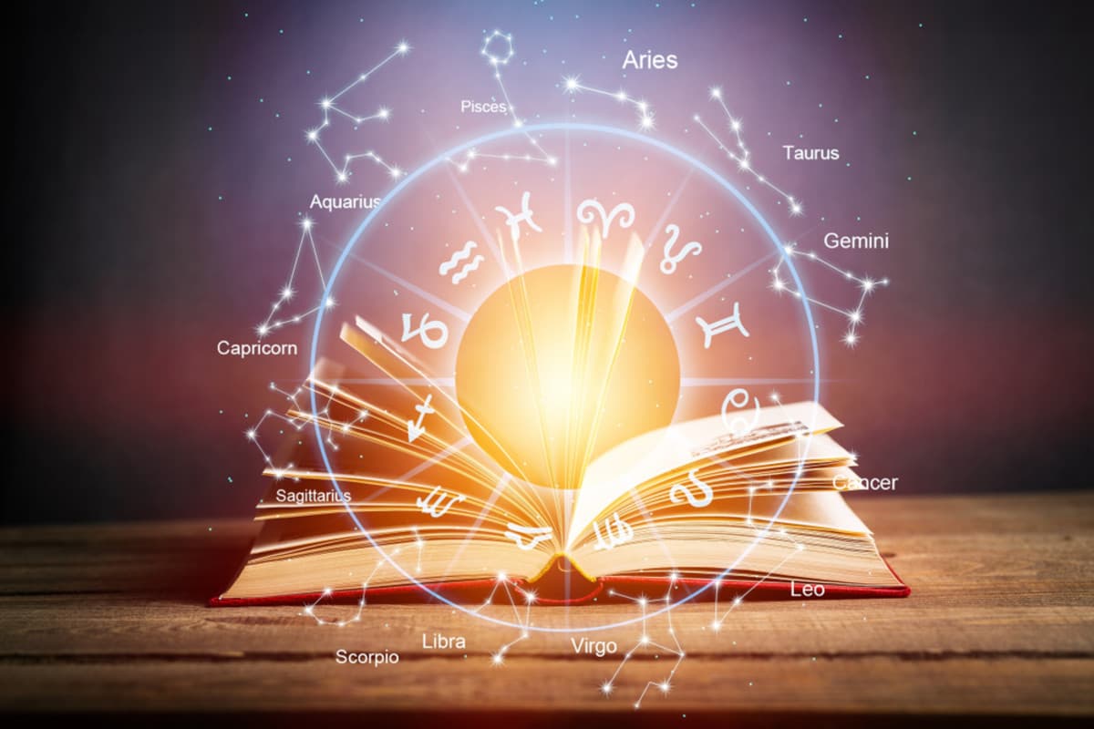A zodiac wheel resting on an open astrology book