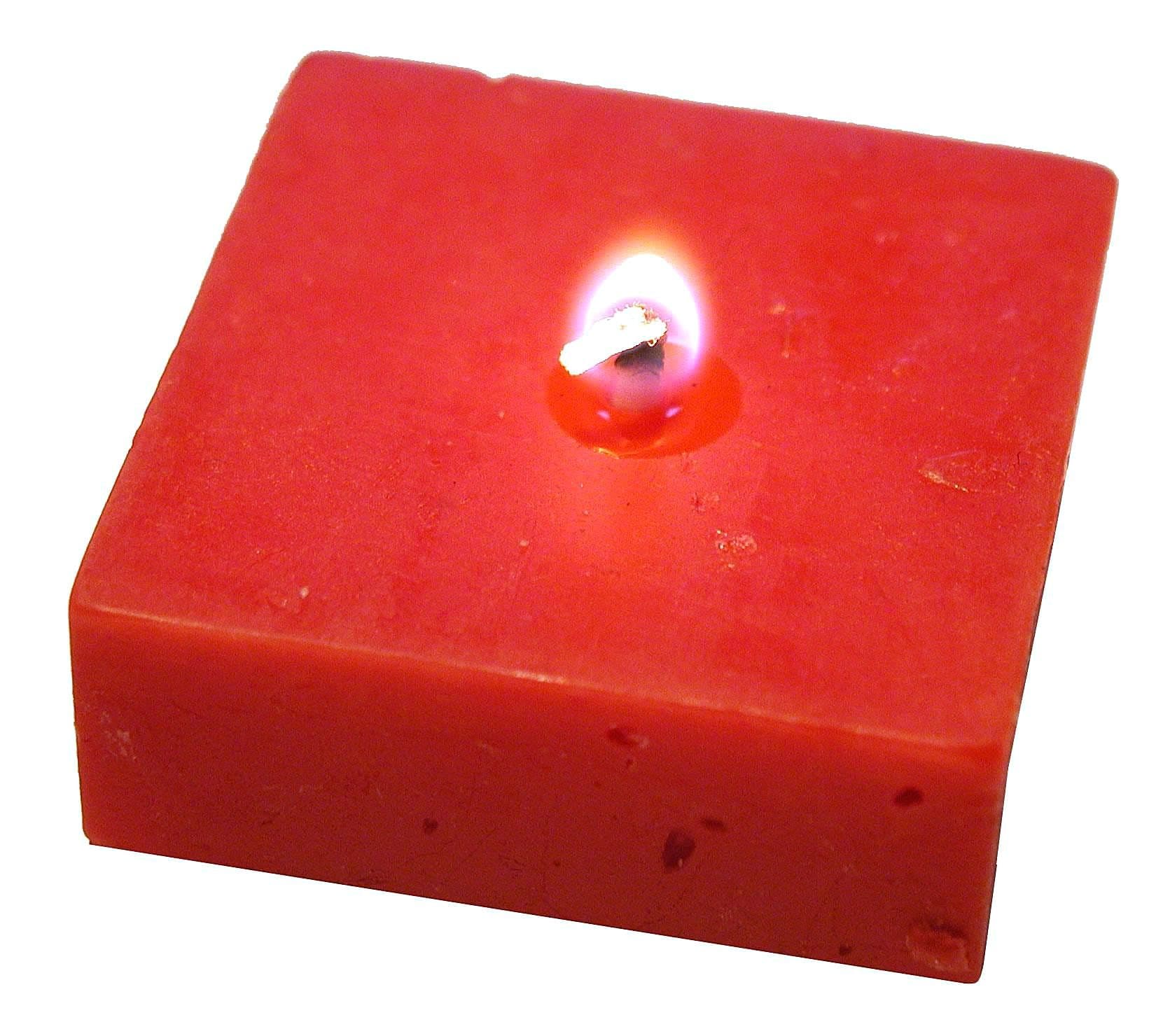 A single lit candle glowing in the dark